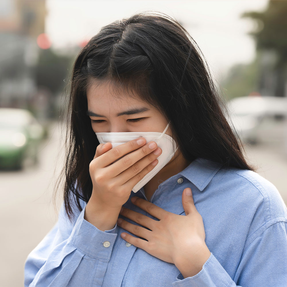 หญิงสาวใช้มือปิดหน้ากาก